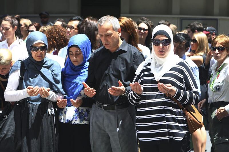 Sydney Muslim community leader Jamal Rifi, centre, and his family members pray at a makeshift memorial after the siege in Sydney. Steve Christo / AP Photo