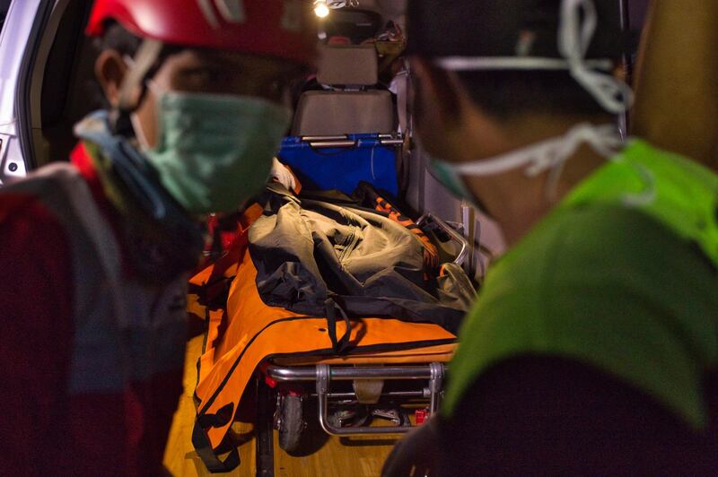Search and rescue workers move the remains of a victim. Getty Images