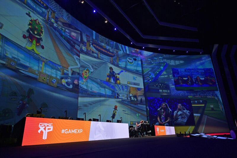 Gamers play Mario Kart on a giant video screen during the Game XP event at the Olympic Park in Rio de Janeiro, Brazil on September 7, 2018. - The four day event aims to be the largest video gaming event in Latin America and attracts computer gamers and comic book enthusiasts. (Photo by CARL DE SOUZA / AFP)