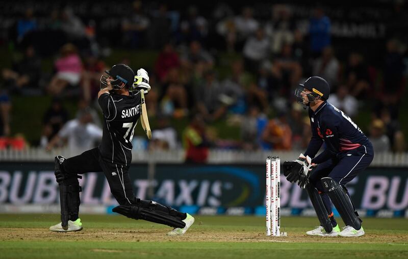 HAMILTON, NEW ZEALAND - FEBRUARY 25:  New Zealand batsman Mitchell Santner hits a six as Jos Buttler looks on during the 1st ODI between New Zealand and England at Seddon Park on February 25, 2018 in Hamilton, New Zealand.  (Photo by Stu Forster/Getty Images)