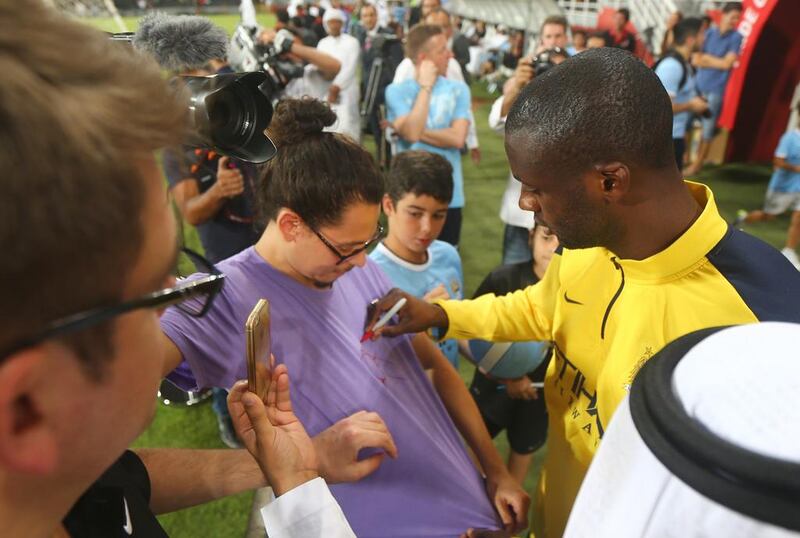 Manchester City player Yaya Toure signs an autograph for a fan. Marwan Naamani / AFP