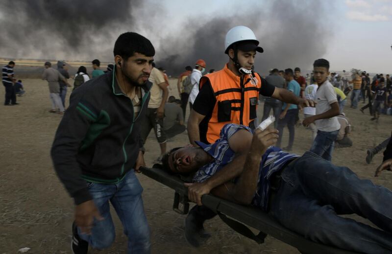 Palestinian medics and protesters evacuate a wounded youth near the Gaza Strip's border with Israel, during a protest east of Khan Younis, in the Gaza Strip, Friday, June 1, 2018. (AP Photo/Adel Hana)