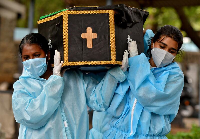 Volunteers Akshaya, 22, right, a law student, and Esther Mary, 41, a lecturer, carry the body of a Covid-19 victim for burial at a cemetery in Bengaluru, India. Reuters