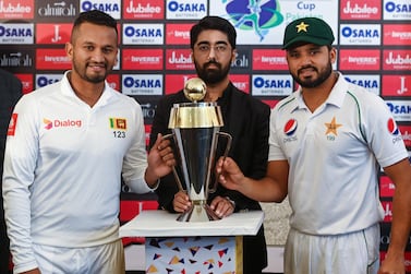 Pakistan's captain Azhar Ali (R) and his Sri Lankan counterpart Dimuth Karunaratne (L) pose for a photograph with Test series trophy at the Pindi Cricket Stadium ahead of the first Test cricket match between Pakistan and Sri Lanka in Rawalpindi on December 10, 2019. / AFP / Aamir QURESHI
