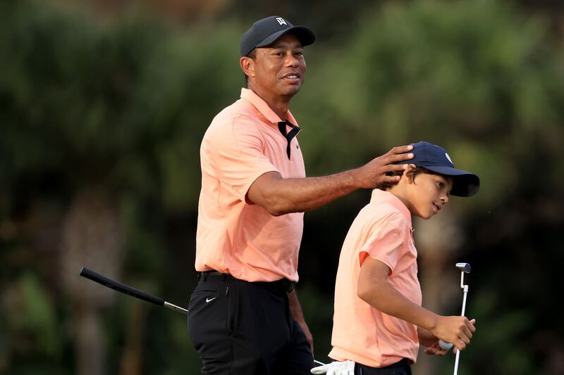 Tiger Woods and Charlie celebrate a birdie on the 15th hole. AFP