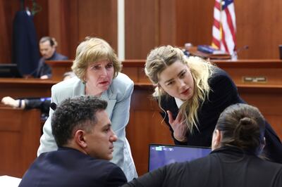 Actress Amber Heard speaks with her legal team. AP