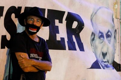 (FILES) A file photo taken on May 09, 2020 shows an Israeli protester, wearing a protective mask bearing the slogan "Crime Minister" and standing with others distanced two metres apart from each other due to the COVID-19 coronavirus pandemic, attending a demonstration in Rabin Square in the Israeli coastal city of Tel Aviv, calling for "a quality government" before the formation of a new government later in the week amid negotiations between Prime Minister Benjamin Netanyahu and his ex-rival Benny Gantz. A new page in Israeli history opens Sunday as Prime Minister Benjamin Netanyahu becomes the first sitting premier to face criminal charges, accused of a string of corruption allegations he denies. After more than 500 days of electoral deadlock in which he fought for his political survival Netanyahu is to take his seat in the Jerusalem District Court for a new battle -- to stay out of prison and avoid a stain on his legacy. / AFP / JACK GUEZ
