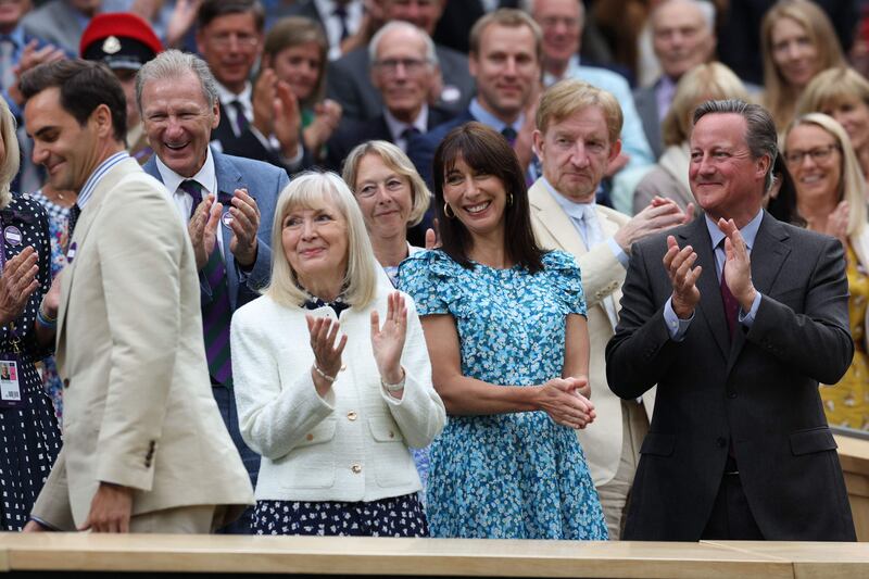 British former Prime Minister David Cameron, right, and his wife Samantha, second right, applaud as Roger Federer arrives at the Centre Court's Royal Box. AFP