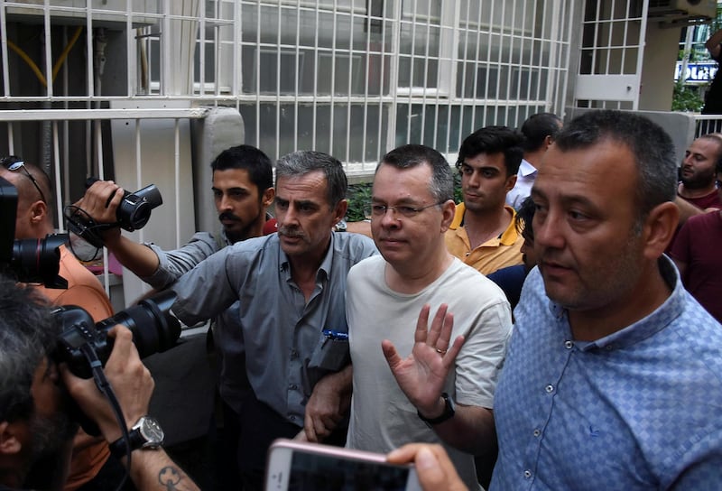 American Pastor Andrew Craig Brunson, a 50-year-old evangelical pastor from Black Mountain, North Carolina, center, waves as he leaves a prison outside Izmir, Turkey, Wednesday, July 25, 2018. Brunson who had been jailed in Turkey for more than 1 Â½ years on terror and espionage charges was released Wednesday and will be put under house arrest as his trial continues. Pastor Brunson was let out of jail to serve home detention because of "health problems," Turkey's official Anadolu news agency said.(DHA via AP)