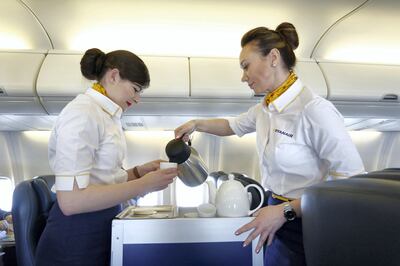 Air stewardesses serve coffee in the cabin of the Ryanair Holdings Plc corporate jet during a flight to Dublin, Ireland, on Tuesday, April 12, 2016. Ryanair attracted more than 100 million travelers for the first time in 2015 and is set to overtake EasyJet Plc as the biggest airline operating in the U.K., with a total of 41 million passengers forecast this year, chief executive officer Michael O'Leary said. Photographer: Luke MacGregor/Bloomberg