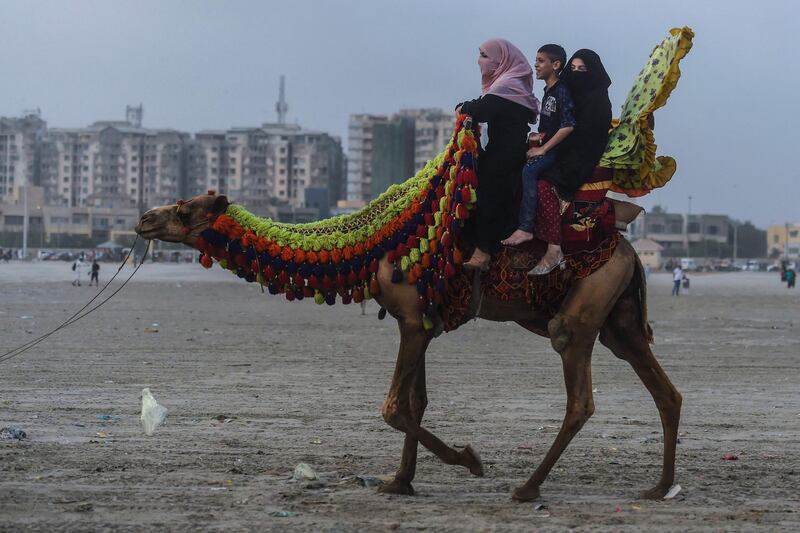 People ride a horse at the Clifton beach in the port city of Karachi after the government eased restrictions. AFP