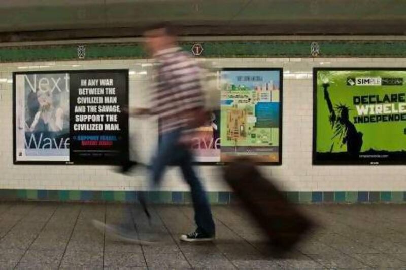 A commuter walks past an anti-Muslim poster in New York's Times Square subway station.  A federal judge ruled that the advertisement is protected speech under the First Amendment of the US Constitution.