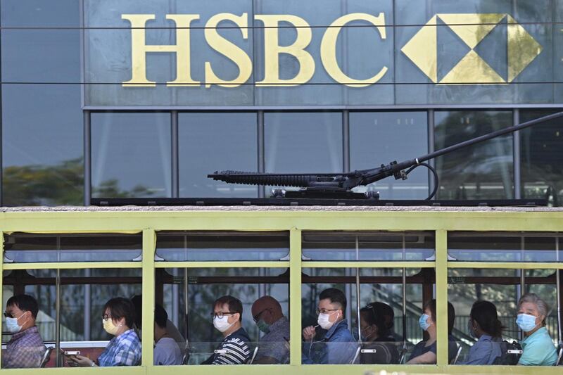 Commuters wearing face masks travel on a tram past HSBC signage displayed outside the bank’s local headquarters in Hong Kong. The London-based, Asia-focused banking giant HSBC is expected to release its first-quarter results on April 28 amid affects of the COVID-19 coronavirus pandemic.  AFP