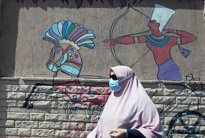 epa08528856 A woman wearing protective face mask walks near wall painting on a street in Cairo, Egypt, 05 July 2020. Countries around the world are taking increased measures to stem the widespread of the SARS-CoV-2 coronavirus which causes the COVID-19 disease.  EPA/KHALED ELFIQI