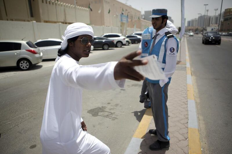 A student pleads with a Mawaqif officer after receiving a ticket near his university. Sammy Dallal / The National