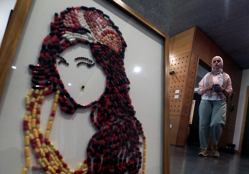 Egyptian artist Amal Salah, 35, stands by her artwork "You Know I'm No Good", made of medicine pills, depicting late singer Amy Winehouse, as part of a mental health project in Cairo, Egypt. Reuters