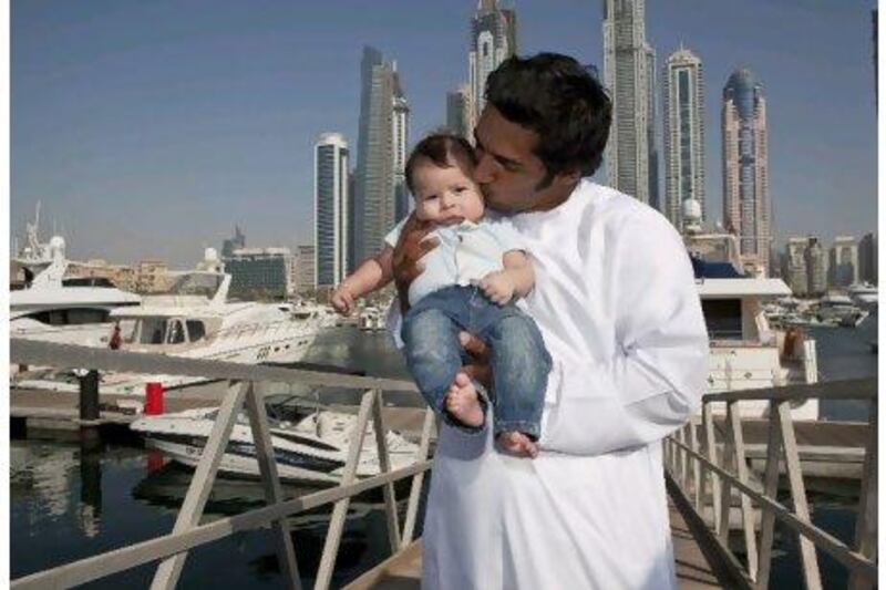 Adil Khalid, the only Emirati crew member of the Abu Dhabi Ocean Racing yacht Azzam, with his three-month-old son Abdul Raffa at the Dubai Marine Club.