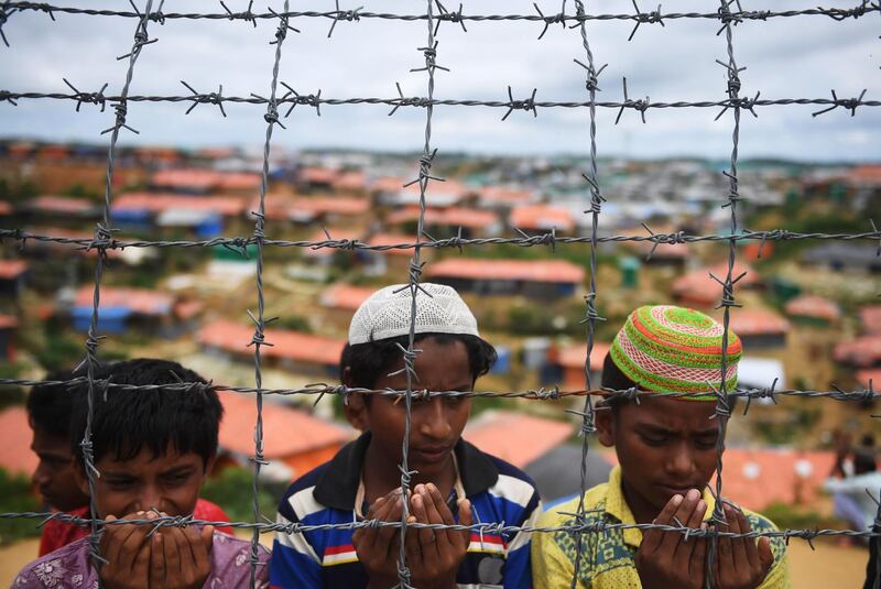 (FILES) In this file photo taken on August 25, 2018 Rohingya refugees perform prayers as they attend a ceremony organised to remember the first anniversary of a military crackdown that prompted a massive exodus of people from Myanmar to Bangladesh, at the Kutupalong refugee camp in Ukhia.




 Canadian lawmakers on September 20, 2018 unanimously voted to declare Myanmar's military against the Rohingya people a "genocide."The House of Commons endorsed the findings of a UN fact-finding mission on Myanmar that found "crimes against humanity have been committed against the Rohingya" and that these acts were sanctioned by top Myanmar military commanders.

 / AFP / Dibyangshu SARKAR
