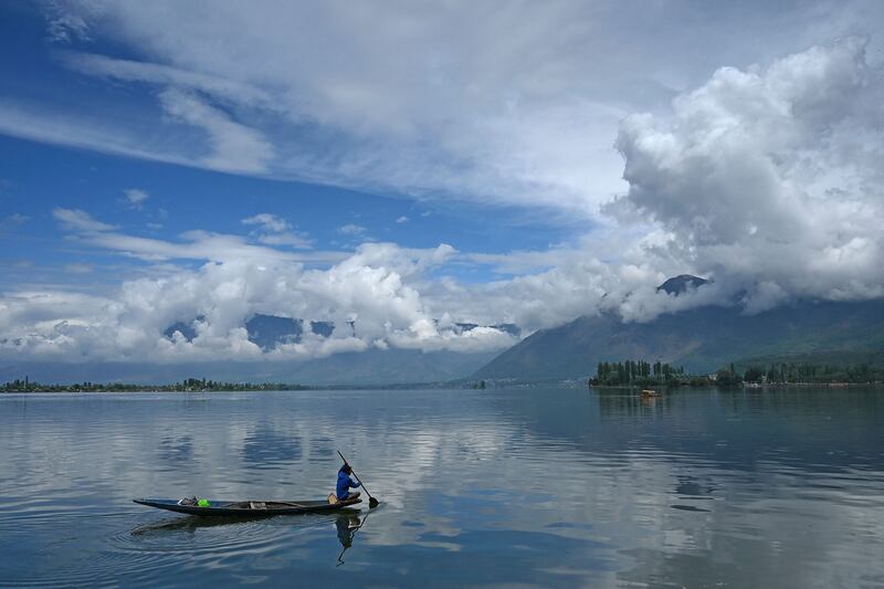 A man steers his boat through Dal Lake in Srinagar, India. AFP