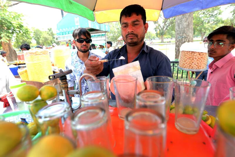 A vendor offers lemon water and lemonade to customers in New Delhi. Weather experts say reckless construction of houses, offices and roads to accommodate the city's expanding population and economy has pushed it to the brink of collapse. EPA
