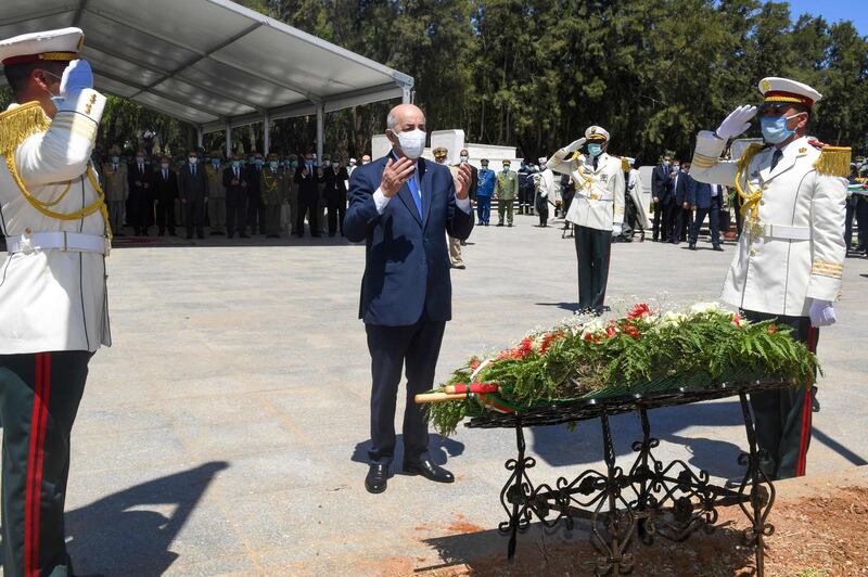 Algeria's President Abdelmajid Tebboune prays during a ceremony to lay to rest the remains of 24 resistance fighters, returned from Paris. AFP