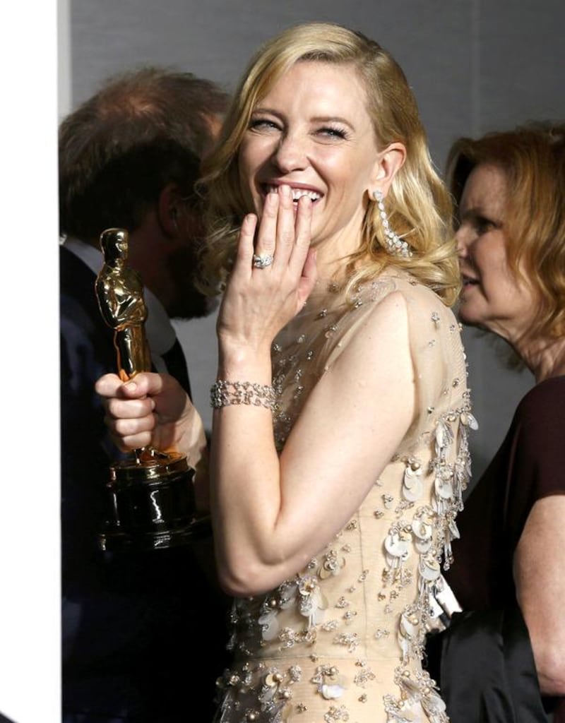 Best actress winner Cate Blanchett looks back as she leaves the photo room with her Oscar. Reuters