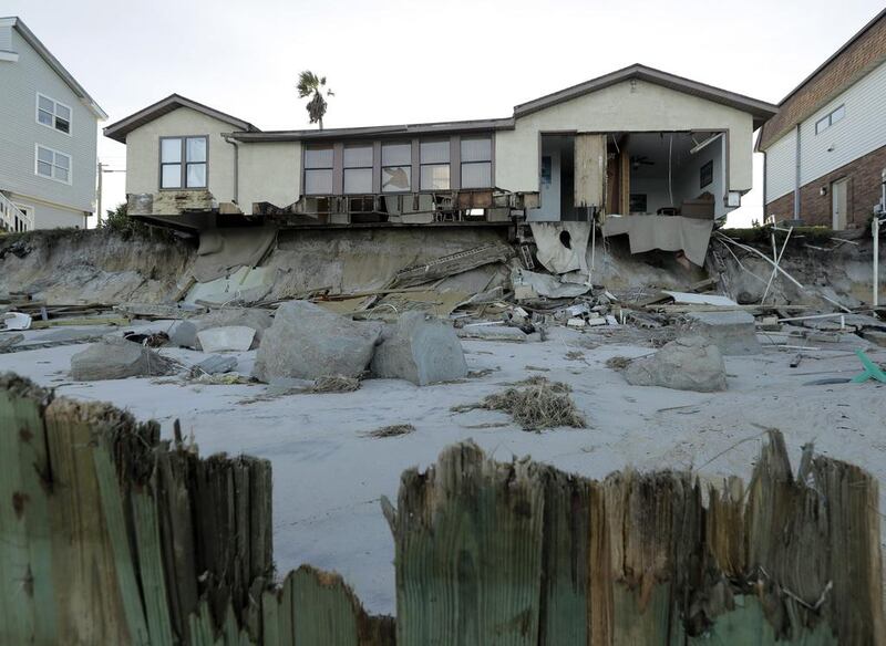 A battered beach house stands beyond a destroyed sea wall at Ponte Vedra Beach, Florida. Charlie Riedel / AP Photo