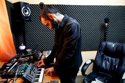 Bruno Cruz, 35, a Palaestinian DJ who contributed to the album "Electrosteen", mixes in his studio in the northern Israeli city of Haifa on February 13, 2019. "Electrosteen" is a collaborative work between artists from the Palestinian territories, Israel, Britain, France and Jordan. Each with their own musical backgrounds, the artists worked from hundreds of pieces of traditional Palestinian music recorded about 15 years ago by the Popular Art Centre. / AFP / AHMAD GHARABLI
