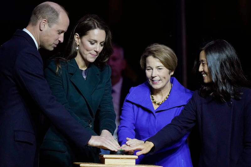 The royal couple join governor-elect Maura Healey, centre, and Ms Wu, right, in pushing a green button to illuminate buildings in Boston with green light. AP