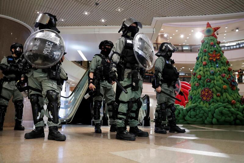 Riot police stand guard next to a Christmas tree inside a shopping mall during an anti-government protest on Christmas Eve at Tsim Sha Tsui in Hong Kong, China, December 24, 2019. REUTERS/Tyrone Siu