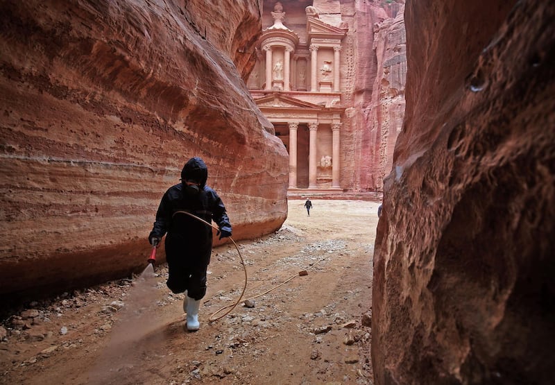 A labourer sprays disinfectant in Jordan's Petra south of the capital Amman to prevent the spread of coronavirus.   AFP