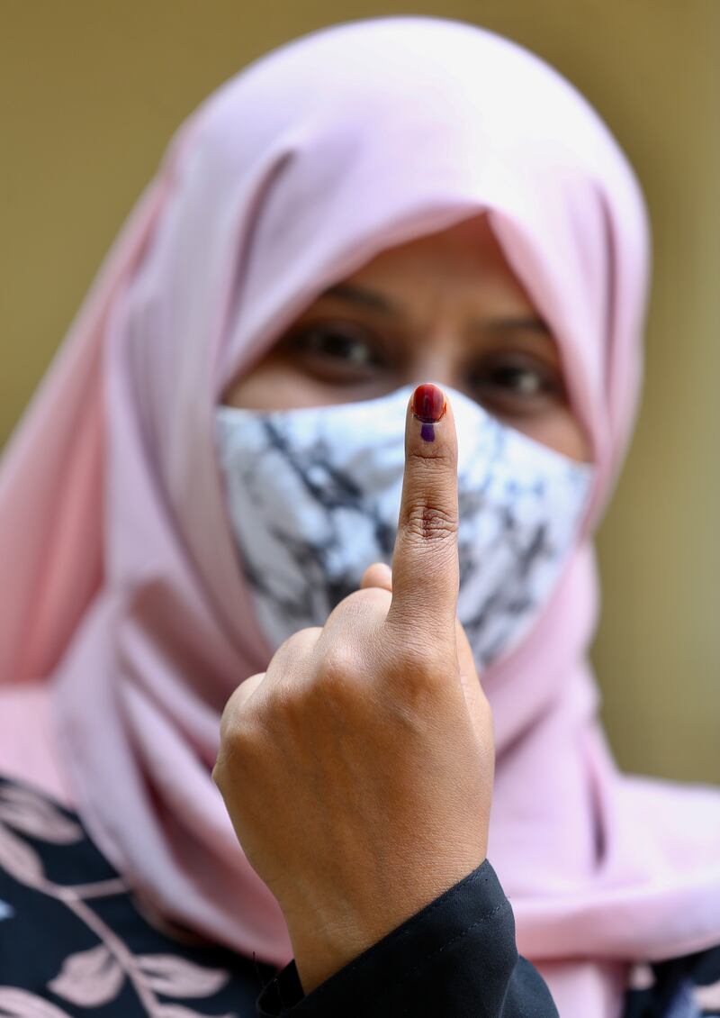 A woman shows her finger after voting at a polling station during the Karnataka election in Bengaluru, India on Wednesday. EPA