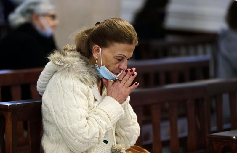 A worshipper wearing a protective mask amid the COVID-19 pandemic attends Christmas morning mass at the Maronite Church of Saint Anthony of Padova in Lebanon's capital Beirut, on December 25, 2020. The church had been damaged in the August 4 blast that tore through Lebanon's capital and resulted from the ignition of a huge depot of ammonium nitrate at Beirut's port. / AFP / ANWAR AMRO
