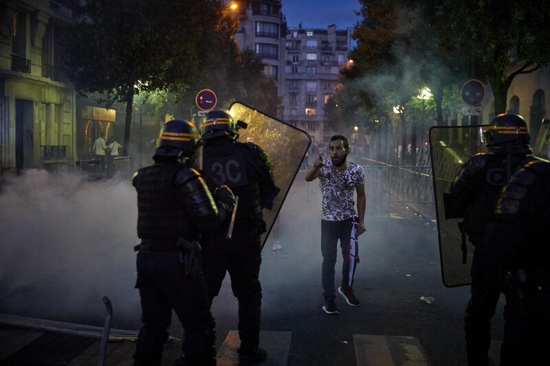 A Paris Saint-Germain fan taunts French riot police outside the Parc de Princes stadium. Getty