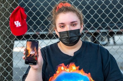 Bryanna Morales, 17, shows a video of the accident at a makeshift memorial at the NRG Park grounds where eight people died during a crowd surge at Astroworld Festival in Houston, Texas. Photo: AFP