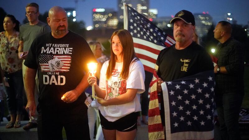 Sydney Robison, centre, looks on during a vigil for Hoover, who had been in the Marines for 11 years. AP