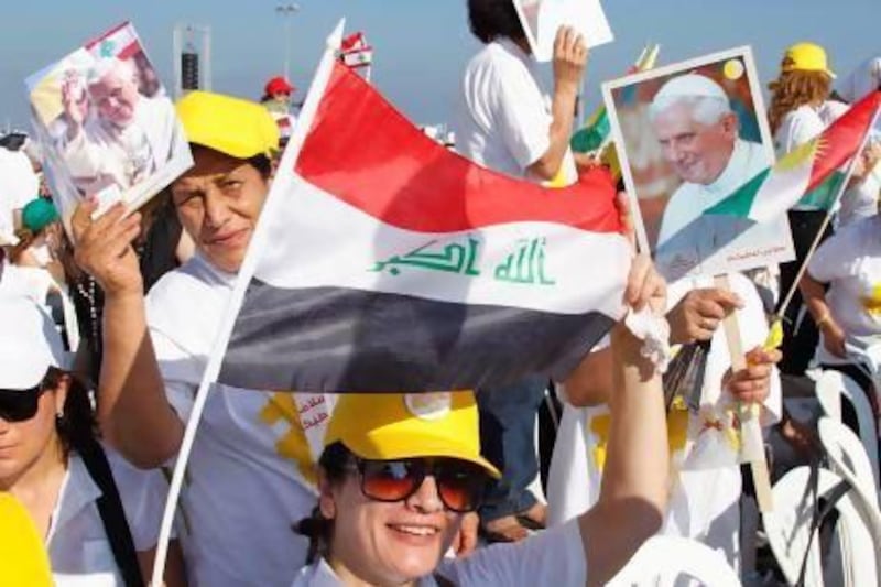 Christians hold up Iraqi and Kurdish national flags, along with Pope Benedict XVI pictures, upon his arrival to conduct an open-air mass in Beirut.