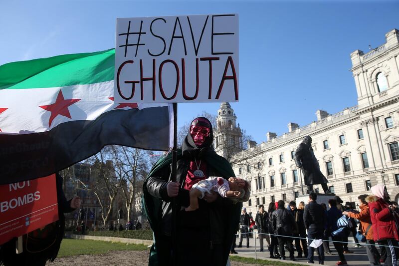 A demonstrator holds a flag and a doll during a Syria solidarity protest outside the Houses of Parliament, in central London. Paul Hackett / Reuters