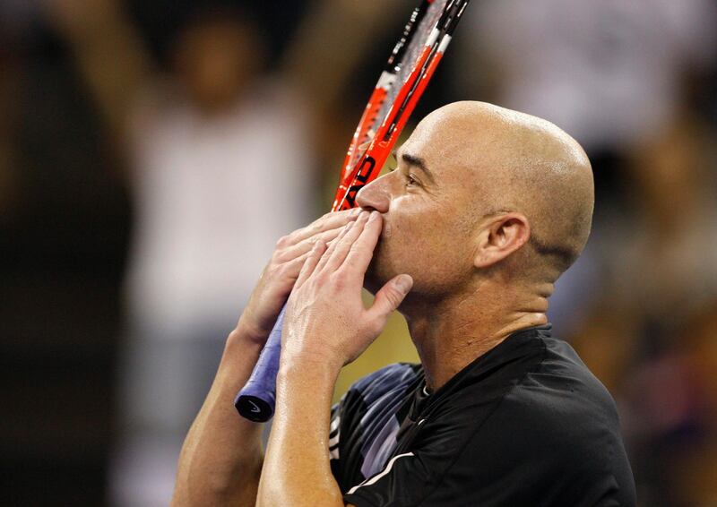 American Andre Agassi gives a fly kiss to fans after defeated by Pete Sampras during a friendly exhibition at the Venetian Hotel in Macau Sunday, Oct. 25, 2009. The two tennis greats revisited one of the sport's greatest rivalries in the 1990s. They last played in the U.S. Open final in 2002. (AP Photo/Vincent Yu) *** Local Caption ***  XVY101_Macau_Sampras_Agassi_.jpg