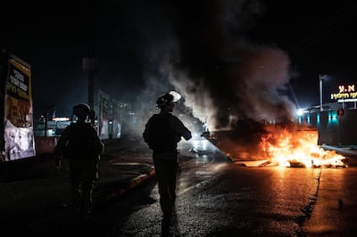 Israeli police patrol during clashes between Arabs, police and Jews, in the mixed town of Lod, central Israel, Wednesday, May 12, 2021. As rockets from Gaza streaked overhead, Arabs and Jews fought each other on the streets below. Rioters torched vehicles, a restaurant and a synagogue in one of the worst spasms of communal violence that Israel has seen in years. (AP Photo/Heidi Levine)