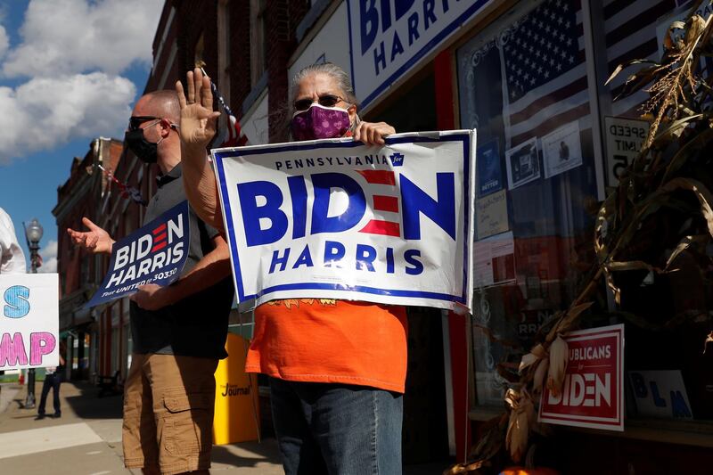 A supporter of U.S. presidential candidate Joe Biden and Vice presidential nominee Kamala Harris waves to drivers outside the Democratic headquarters in Union City, Pennsylvania, U.S. REUTERS