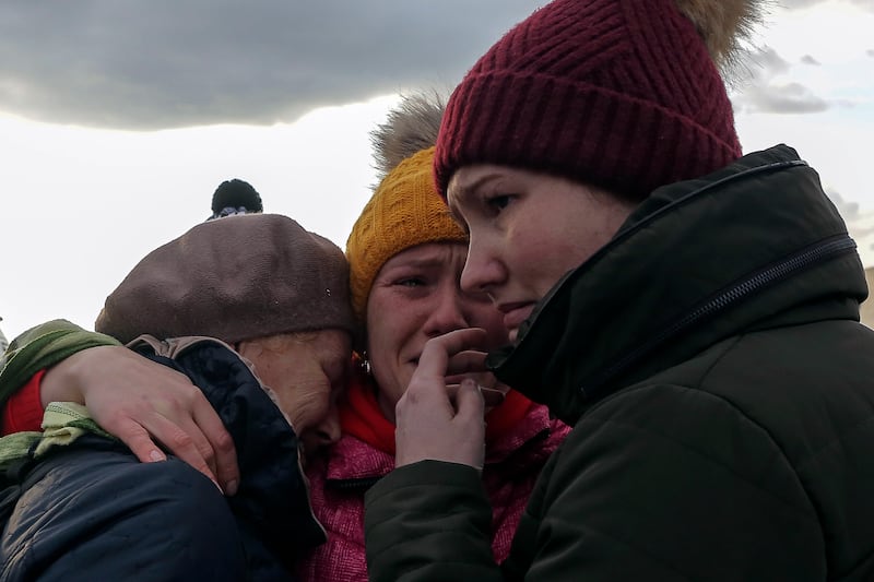 Ukrainian refugees cry as they reunite at the Medyka border crossing in Poland. AP