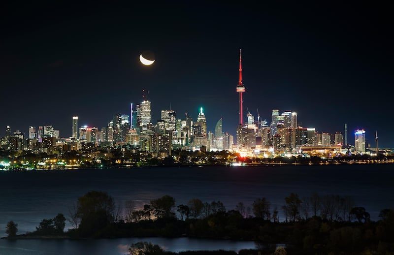 TORONTO, ONTARIO - OCTOBER 23: The moon rises behind the CN Tower and skyline in Toronto on October 23, 2019 in Toronto, Canada. (Photo by Mark Blinch/Getty Images)