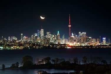 The moon rises behind the CN Tower and skyline in Toronto - a sight much of the world would like to go to bed to. Getty