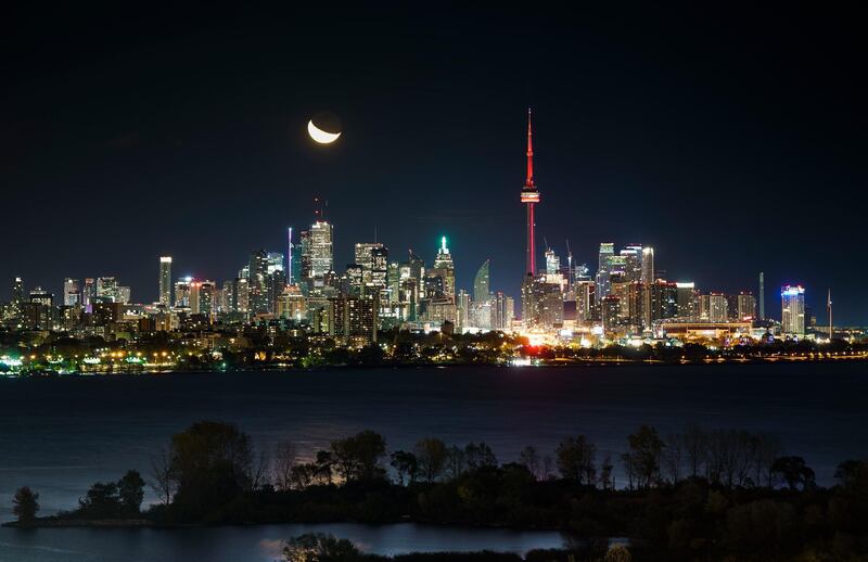 TORONTO, ONTARIO - OCTOBER 23: The moon rises behind the CN Tower and skyline in Toronto on October 23, 2019 in Toronto, Canada. (Photo by Mark Blinch/Getty Images)