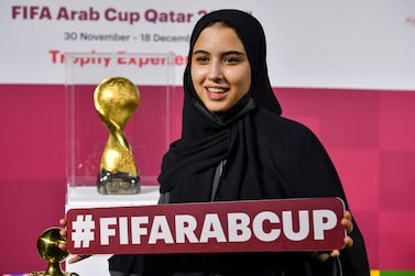 A woman poses next to the FIFA Arab Cup Trophy is displayed during the FIFA Arab Cup Trophy Experience at Katara Cultural Village in Doha, Qatar, 25 November 2021.  The FIFA Arab Cup will take place in Qatar from 30 November to 18 December 2021.   EPA / NOUSHAD THEKKAYIL