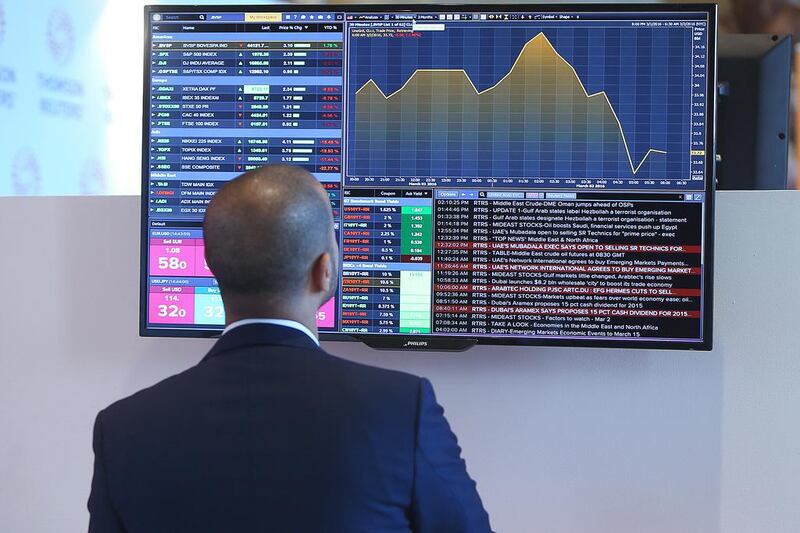 A delegate watches the latest stock market trading information at a television screen during the opening of Global Financial Markets Forum. Ravindranath K / The National