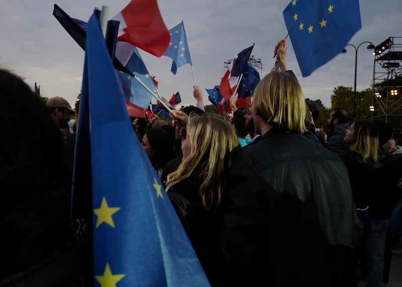 Supporters of the incumbent president waved flags and hugged each other as they chanted 'Macron'. AP Photo