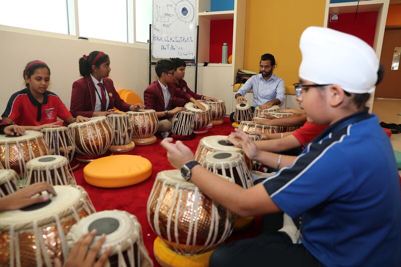 Pupils learning Tabla (a pair of drums from India) in music class