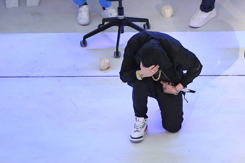 Eminem kneels on stage after his performance during the half-time show of Super Bowl. AFP